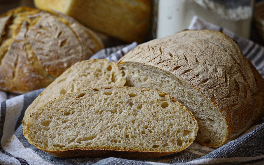 the best sourdough bread sliced open with bread and flour in background 1024x640