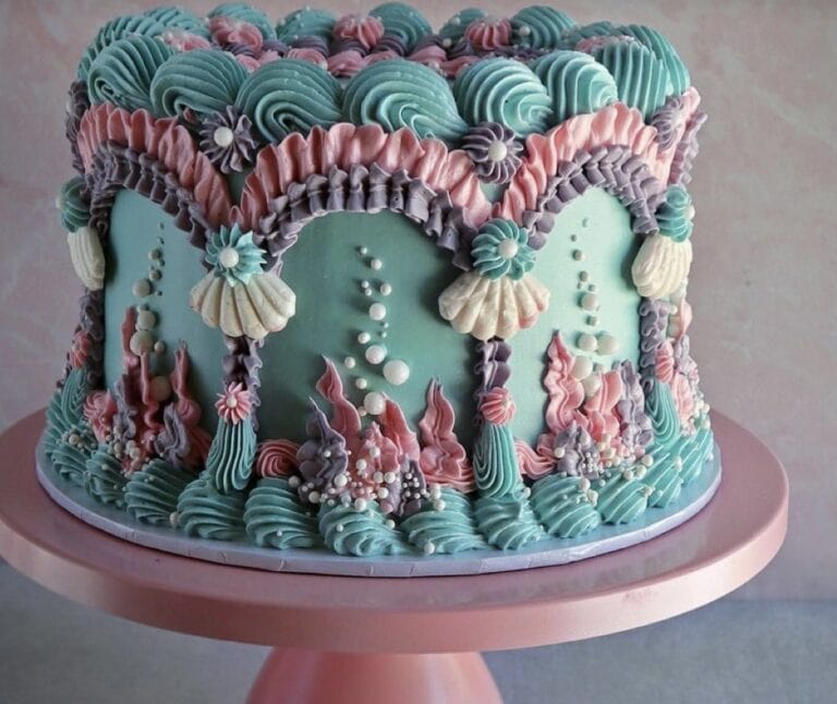 screenshot Colorful mermaid-themed cake with seashell decorations.