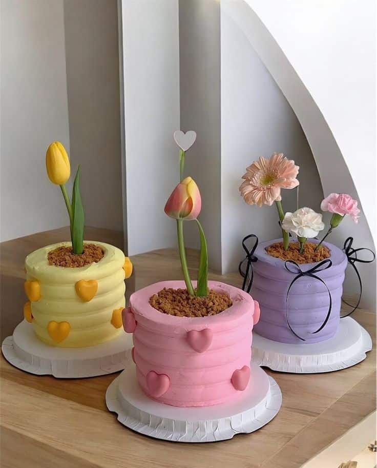 911334e990612adfcdfa044a181ae04a Colorful floral cakes with heart decorations on table.