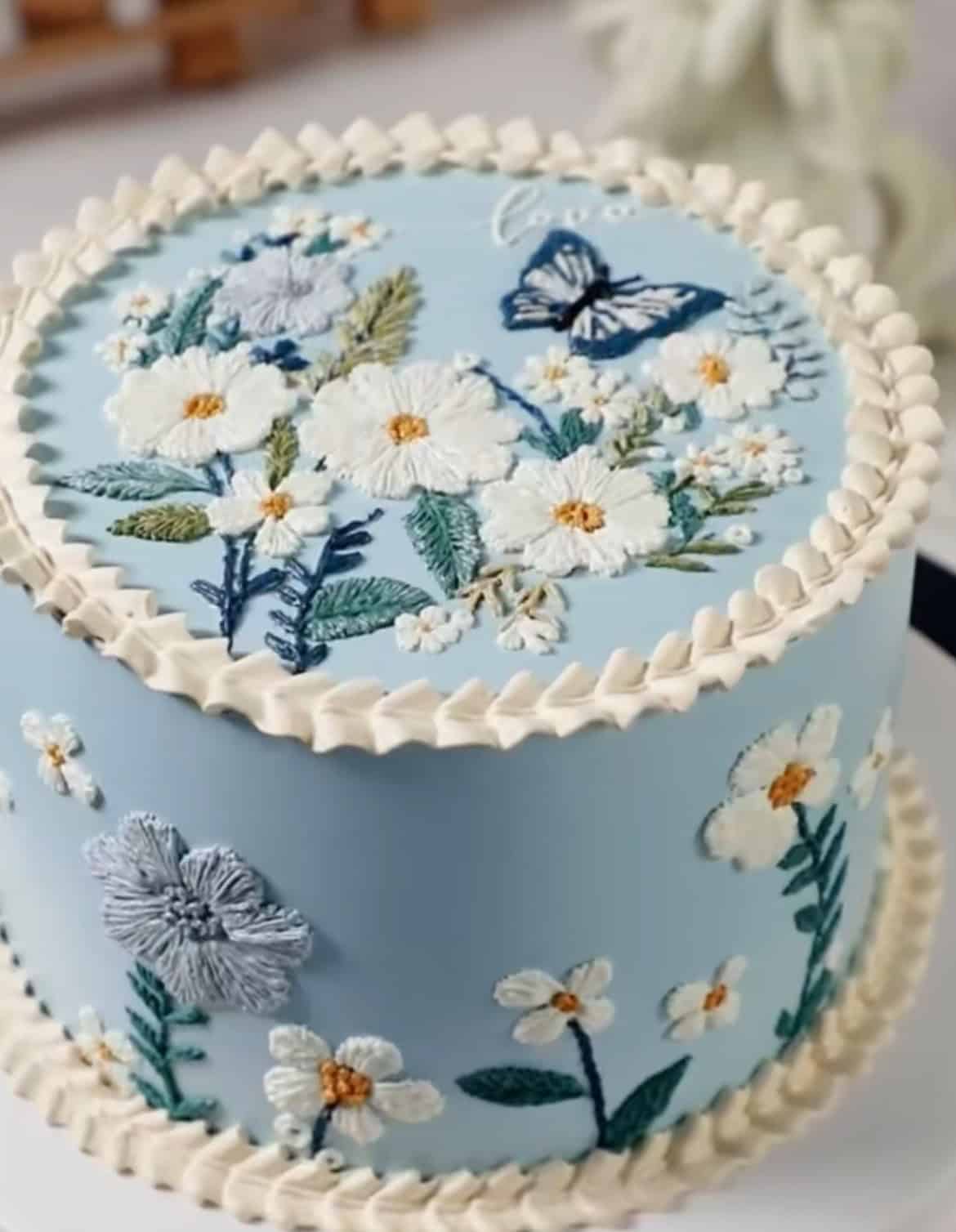 Blue cake with floral buttercream decorations.