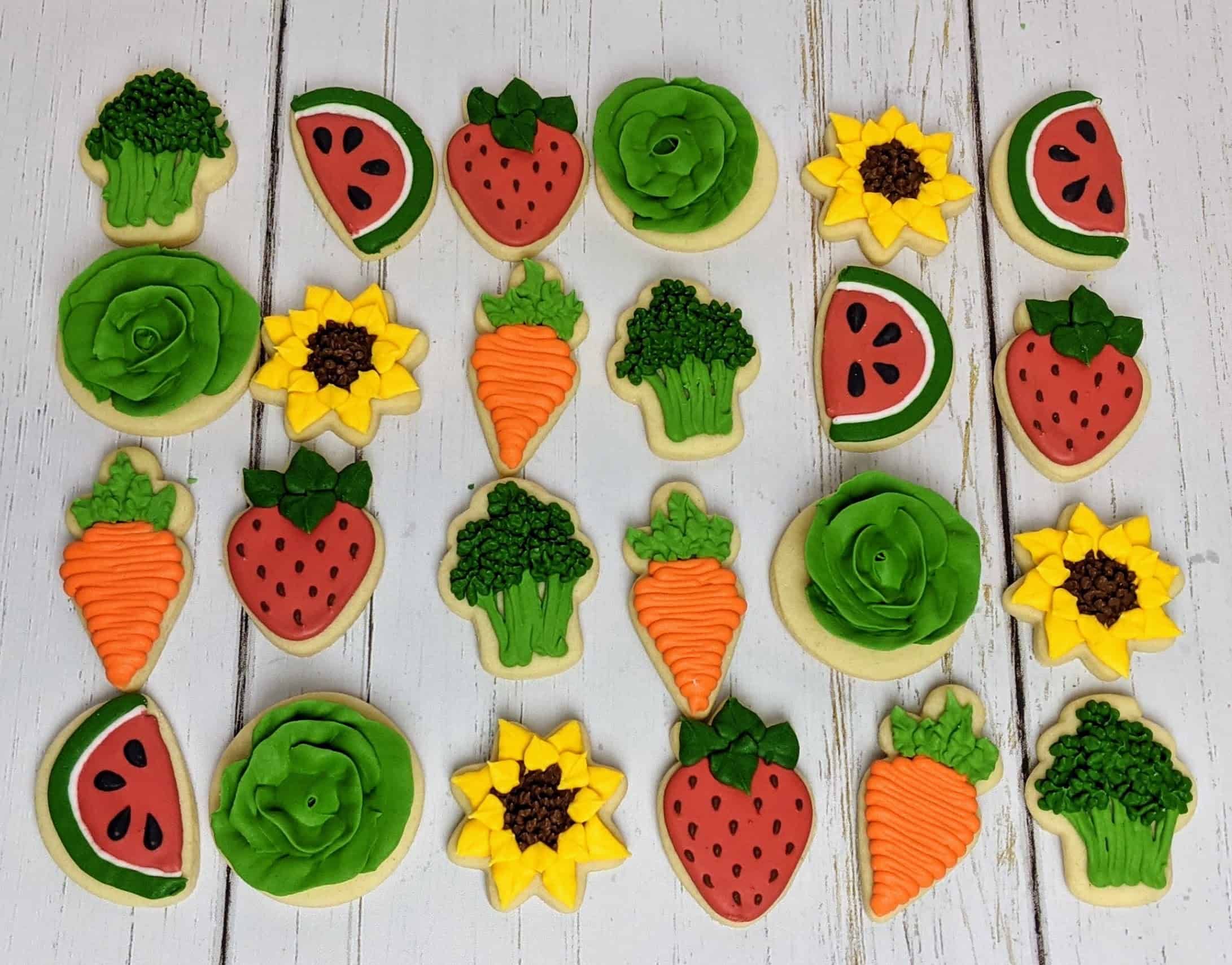 Colorful vegetable and fruit shaped cookies on table.