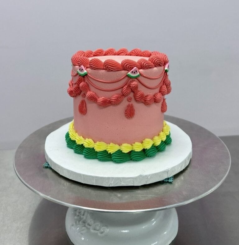 watermelon vintage cake Watermelon-themed cake with frosting decorations.