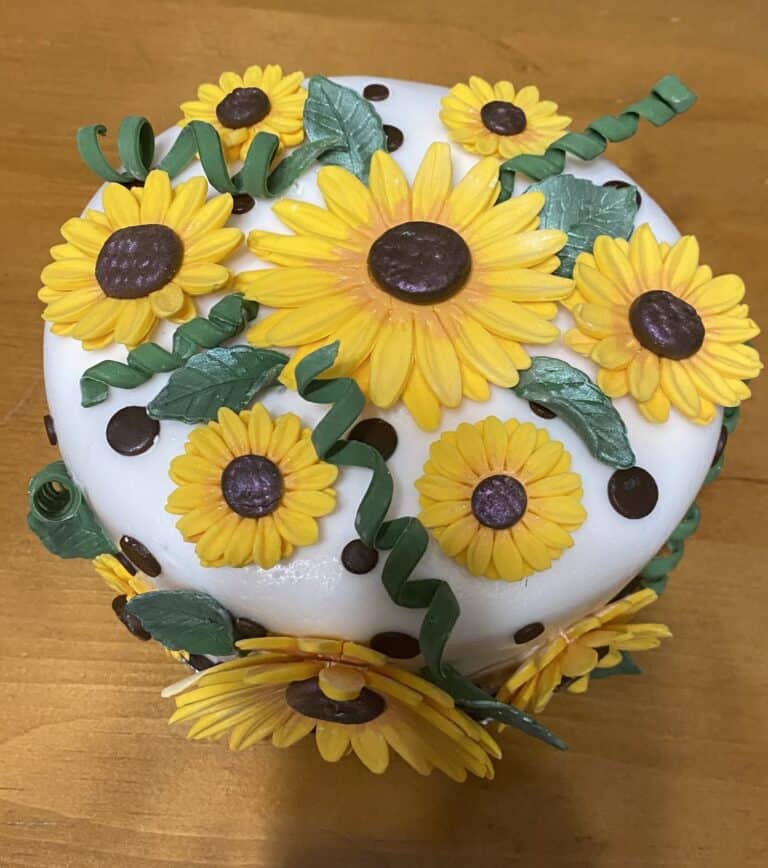 brenda sunflower Sunflower-themed cake with yellow and brown decorations.