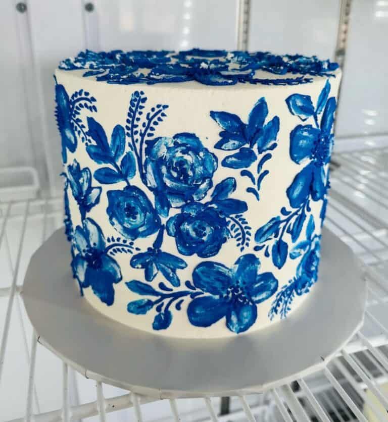 brush embroidery floral White cake with blue floral icing design.