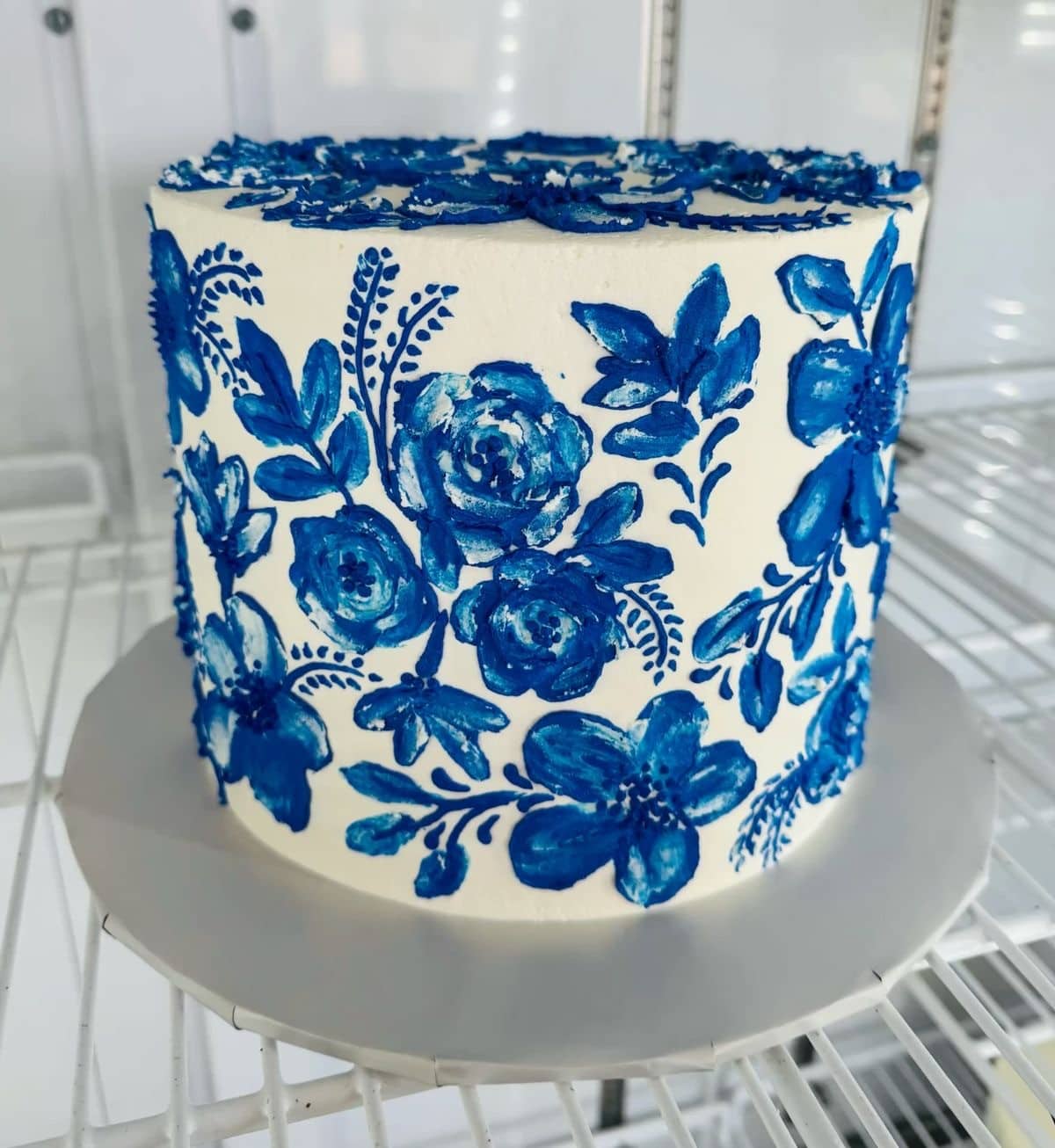 White cake with blue floral icing design.