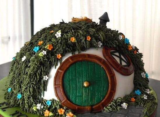 hobbit hole cake Hobbit house cake with green door and flowers.