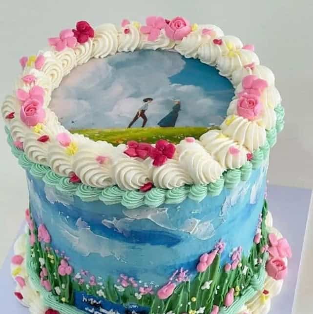 howls moving castle cake Decorated cake with floral and scenic design.