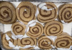 Delicious cinnamon roll slices with swirls and white icing, perfect for cake decorating and dessert supplies from Over the Top Cake Supplies.
