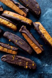 Delicious chocolate-dipped biscotti with a crispy texture and golden zest accents, perfect for baking and cake decorating supplies from Over the Top Cake Supplies.