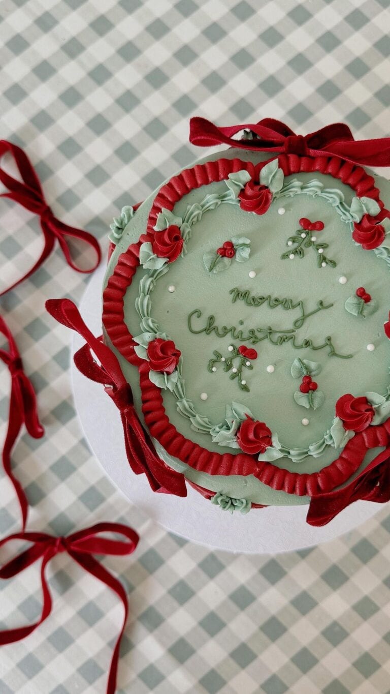 coquette christmas cake Festive holiday-themed Christmas cake with red and green frosting, floral details, and "Merry Christmas" message, perfect for holiday celebrations and dessert tables.