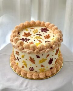 Pumpkin leaf autumn-inspired cake decorated with colorful fall leaves and piped border, perfect for seasonal celebrations and fall-themed events.