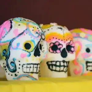 Colorful decorative skull cupcakes with vibrant sugar art for themed celebrations and Halloween parties.