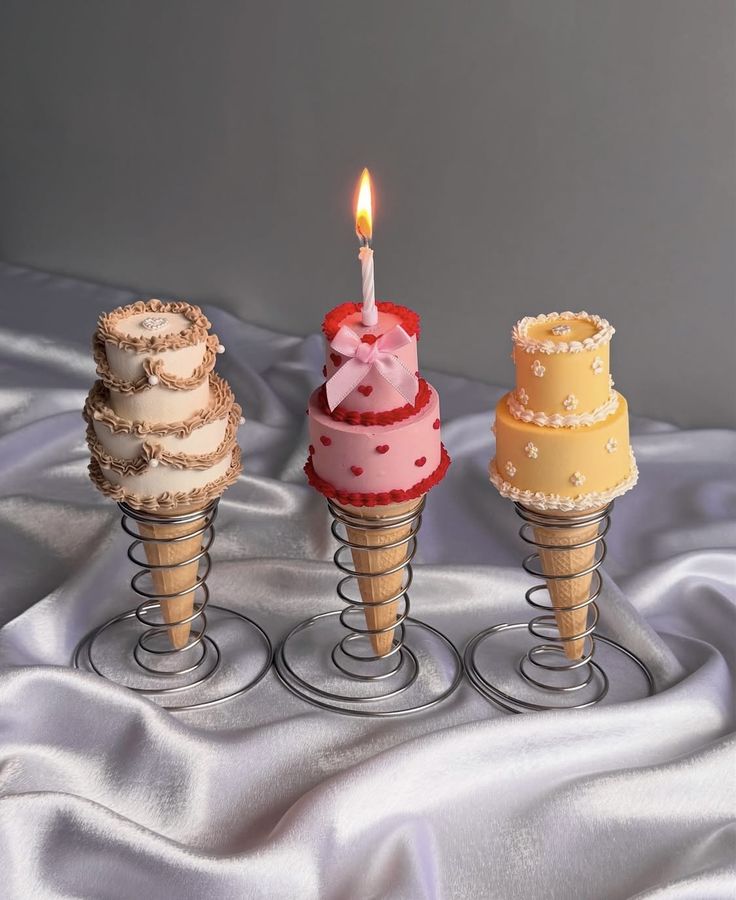 screenshot Miniature cake cones with decorative frosting, perfect for cake decorating and wedding cake supplies, displayed on metal stands.
