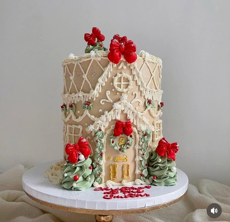 Gingerbread house cake decorated with holiday-themed icing, red bows, Christmas trees, and festive details, perfect for holiday celebrations and festive occasions.