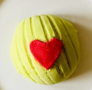 Colorful heart-shaped cake made with vibrant green fondant and a red fondant heart decoration, perfect for special occasions, showcasing top-quality cake supplies from Over the Top Cake Supplies.
