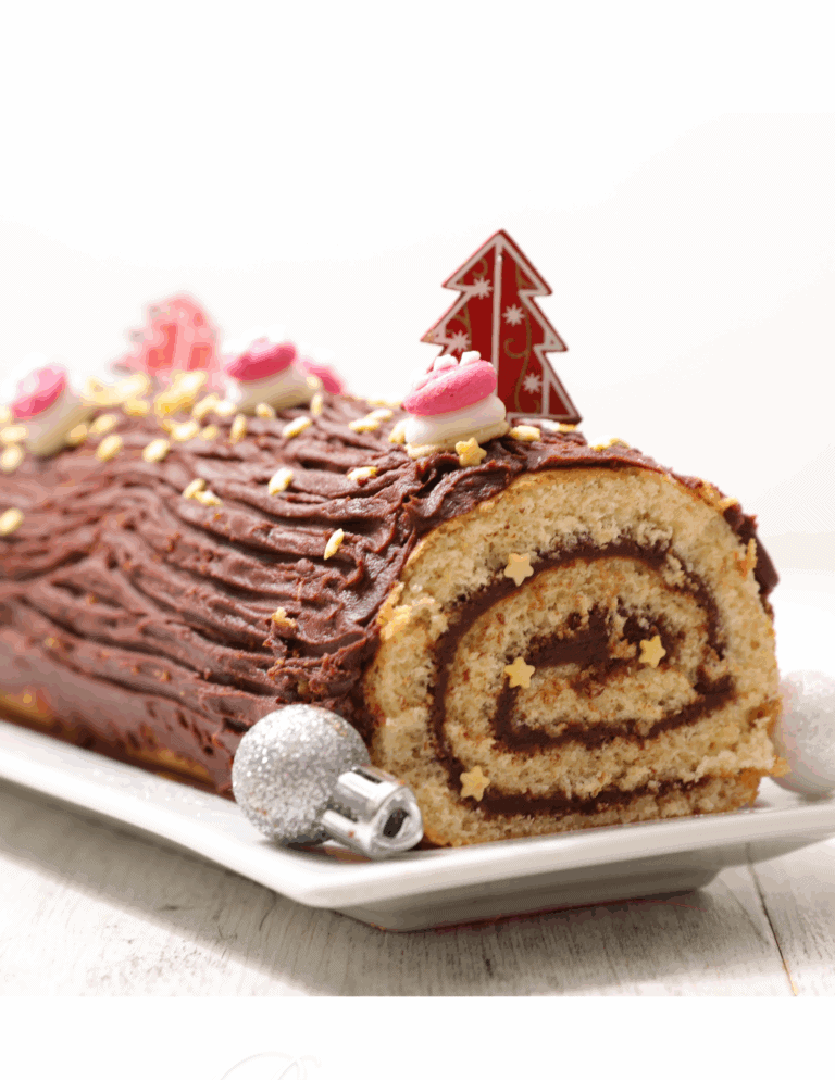 yule log Decorated Christmas yule log cake with chocolate frosting, pink and white fondant accents, edible star sprinkles, and holiday-themed cake topper, on a white serving platter.
