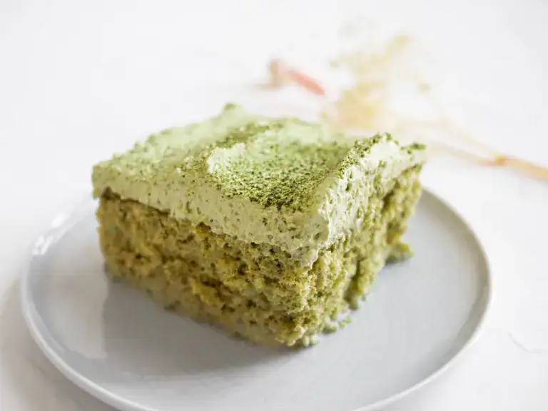 Fresh matcha green tea cake with creamy frosting on a white plate, showcasing premium cake decorating supplies for bakers and cake artists.