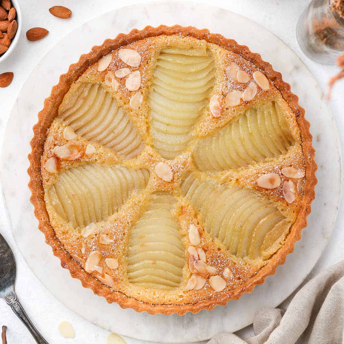 Delicious pear tart topped with sliced almonds, perfect for baking enthusiasts and dessert lovers. Ideal for special occasions or everyday treats.