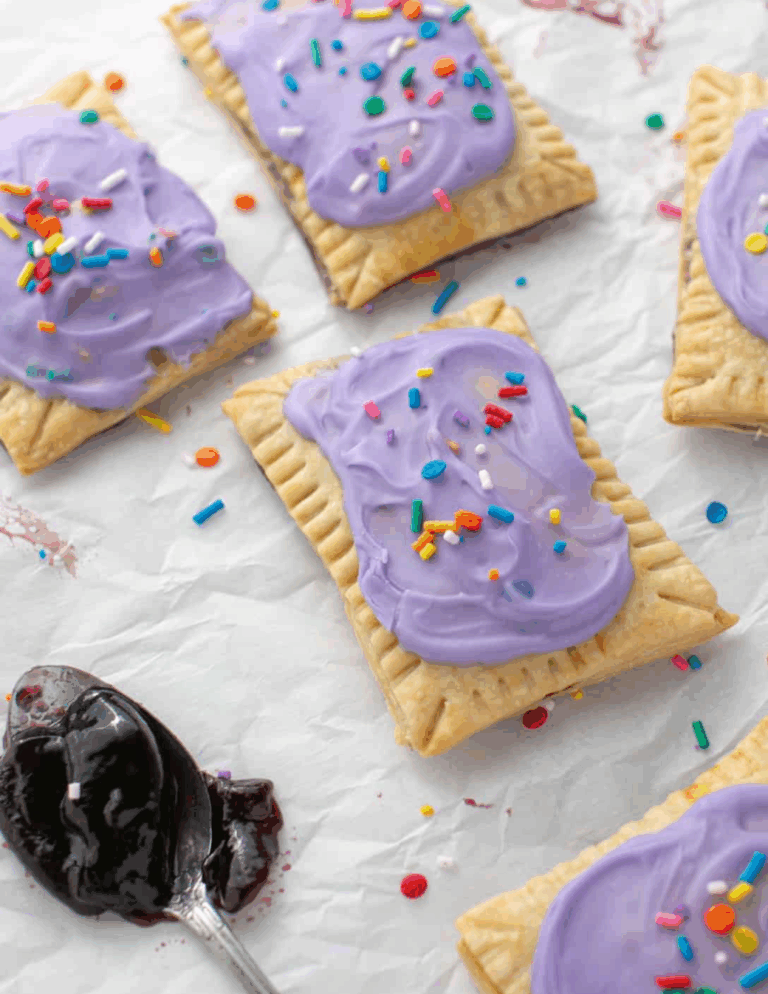 poptarts berryb.sugar Colorful frosted cookies with sprinkles arranged on parchment paper, perfect for custom cake decorating supplies and baking ingredients.