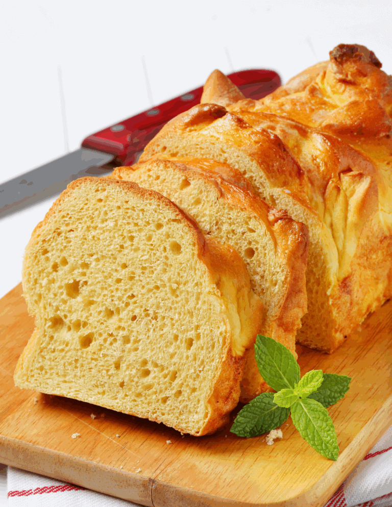 Delicious homemade lemon pound cake sliced on a wooden cutting board with fresh mint, showcasing moist texture and bright lemon flavor. Great for dessert or tea time.