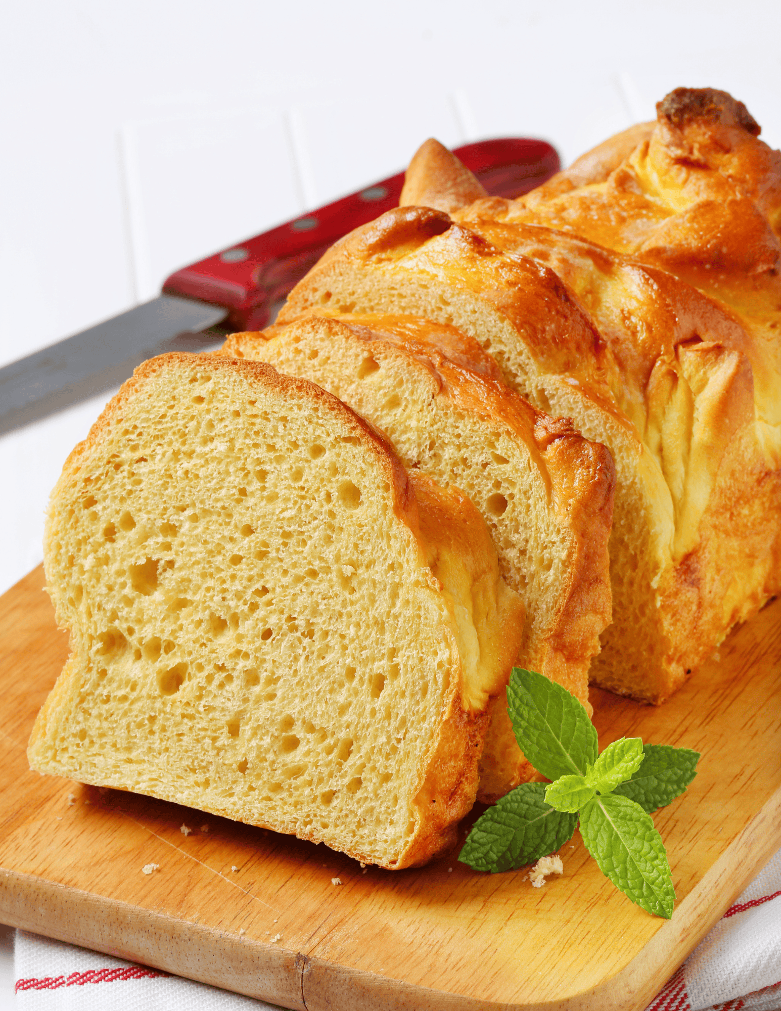 Delicious homemade lemon pound cake sliced on a wooden cutting board with fresh mint, showcasing moist texture and bright lemon flavor. Great for dessert or tea time.