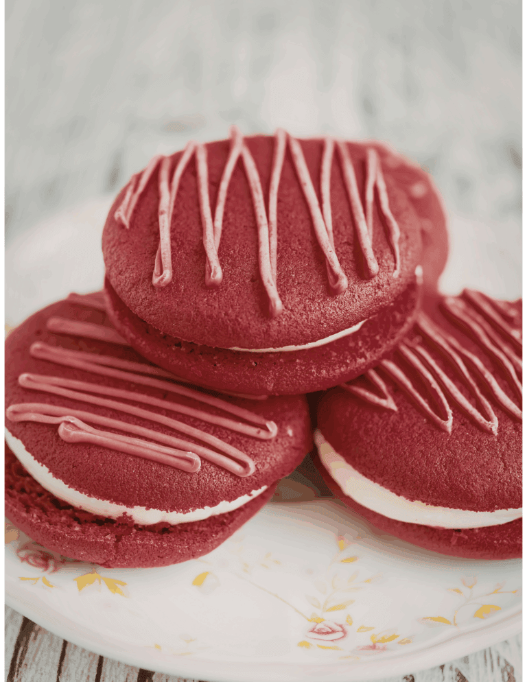 Delicious red velvet cookies with cream filling and pink drizzle, ideal for cake decorating and bakery supplies.