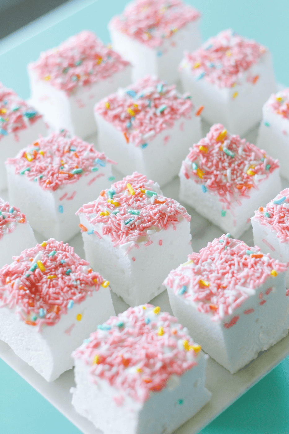 Delicious pink and white marshmallow treats topped with colorful sprinkles, perfect for cake decorating and party treats. Ideal for baking supplies from Over the Top Cake Supplies.