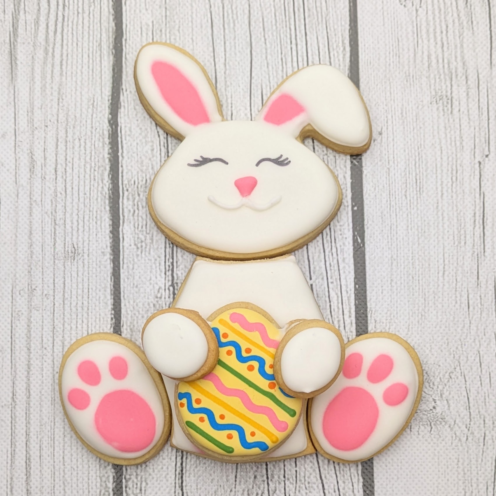 Decorative Easter bunny cookie with detailed icing and colorful Easter egg accents, perfect for spring themed parties and holiday treat platters.