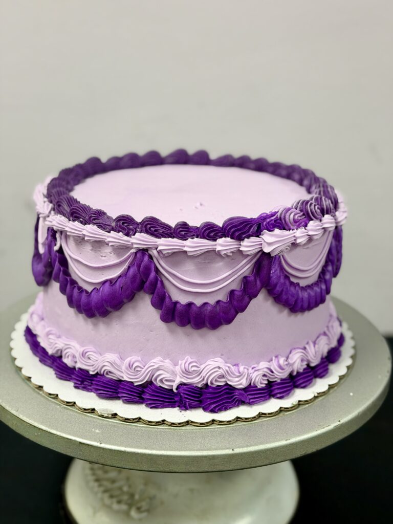 Bright purple and lavender frosting with decorative piped design, perfect for celebrations.