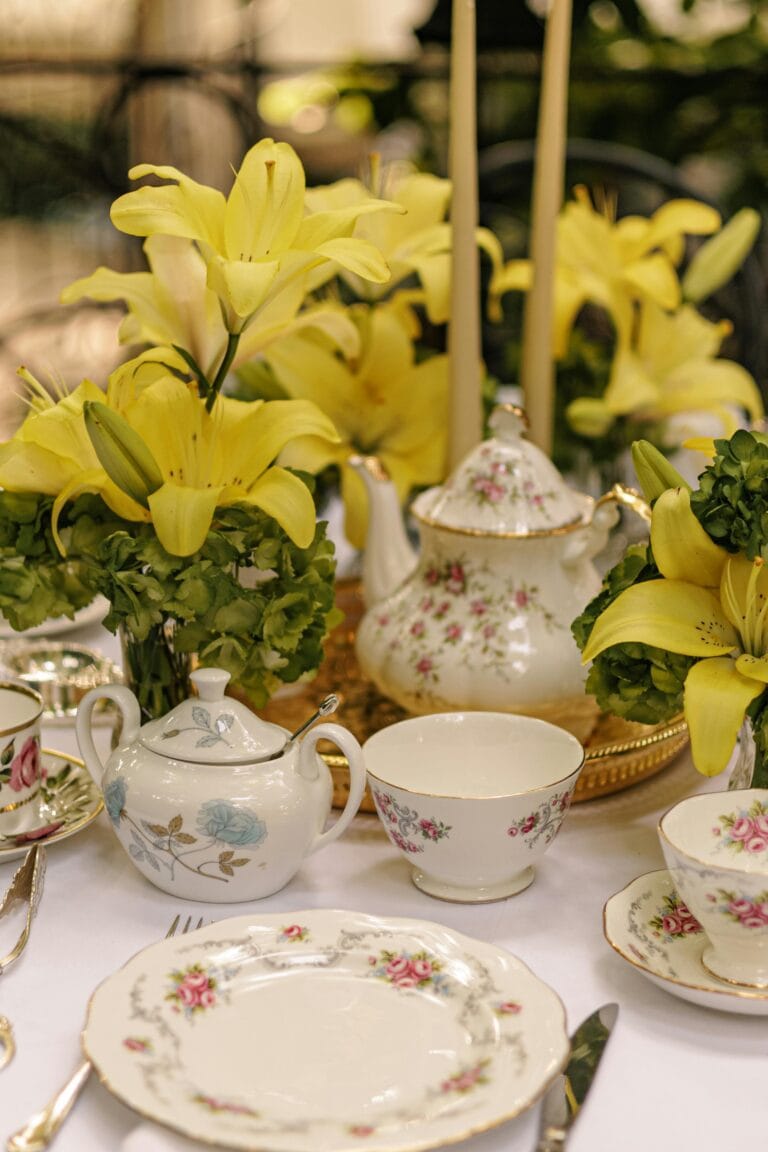 Beautiful porcelain teapot, cups, and saucers with floral designs and gold accents, perfect for wedding or tea party decor.