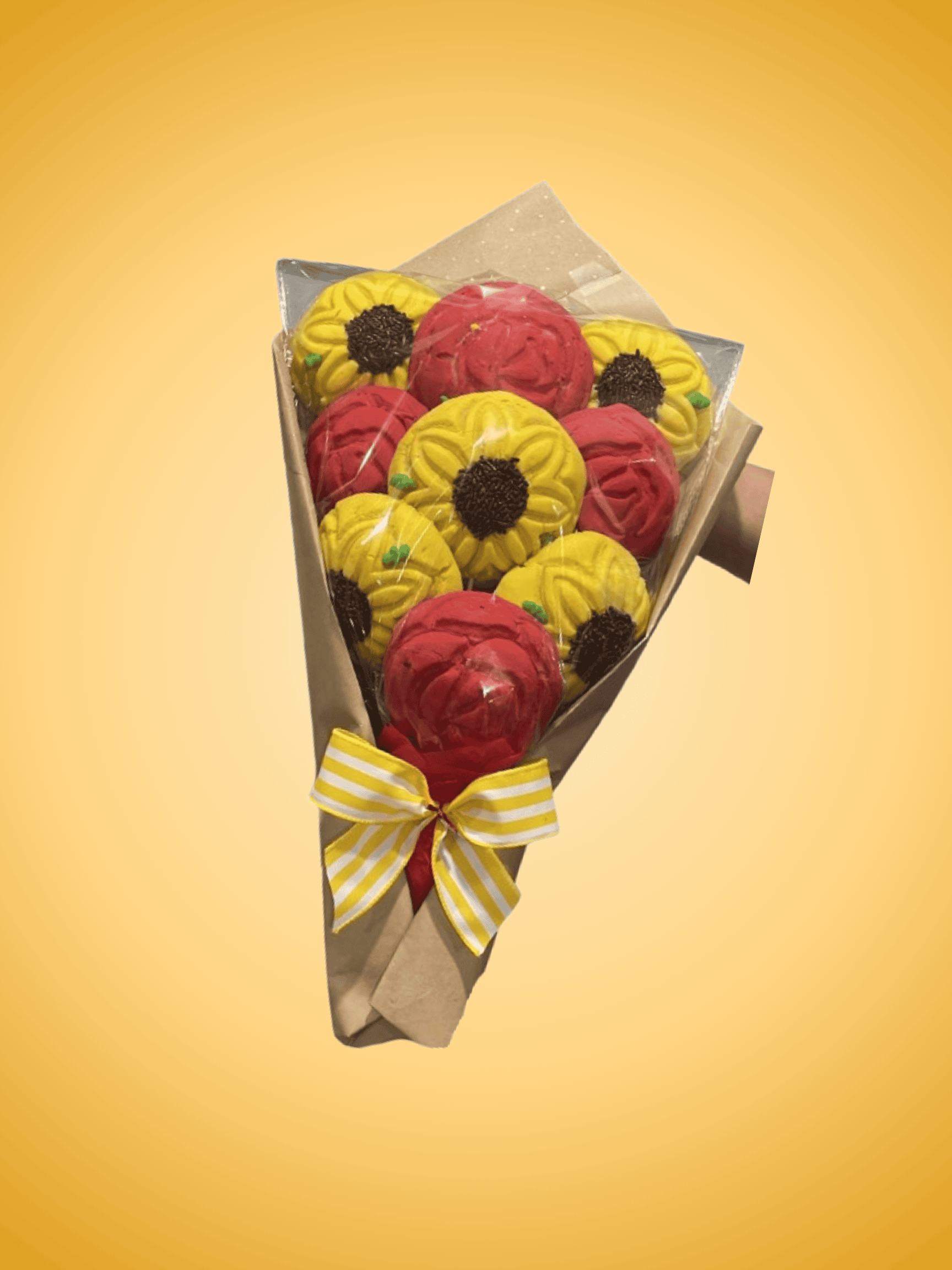 Brightly colored concha-shaped cake decorations arranged in a bouquet, featuring yellow and red conchas with chocolate centers, wrapped in decorative paper with a yellow ribbon.