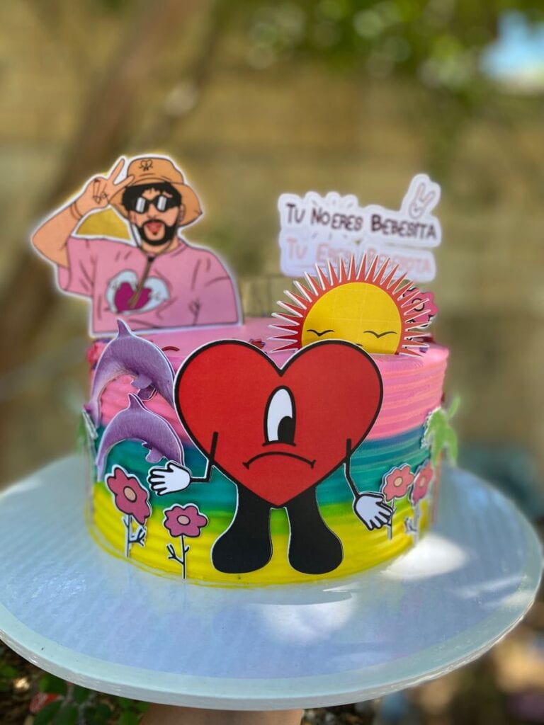 Colorful Bad Bunny-themed cake with heart and cartoon characters, perfect for a birthday celebration. Bright, vibrant, and detailed cake decoration.