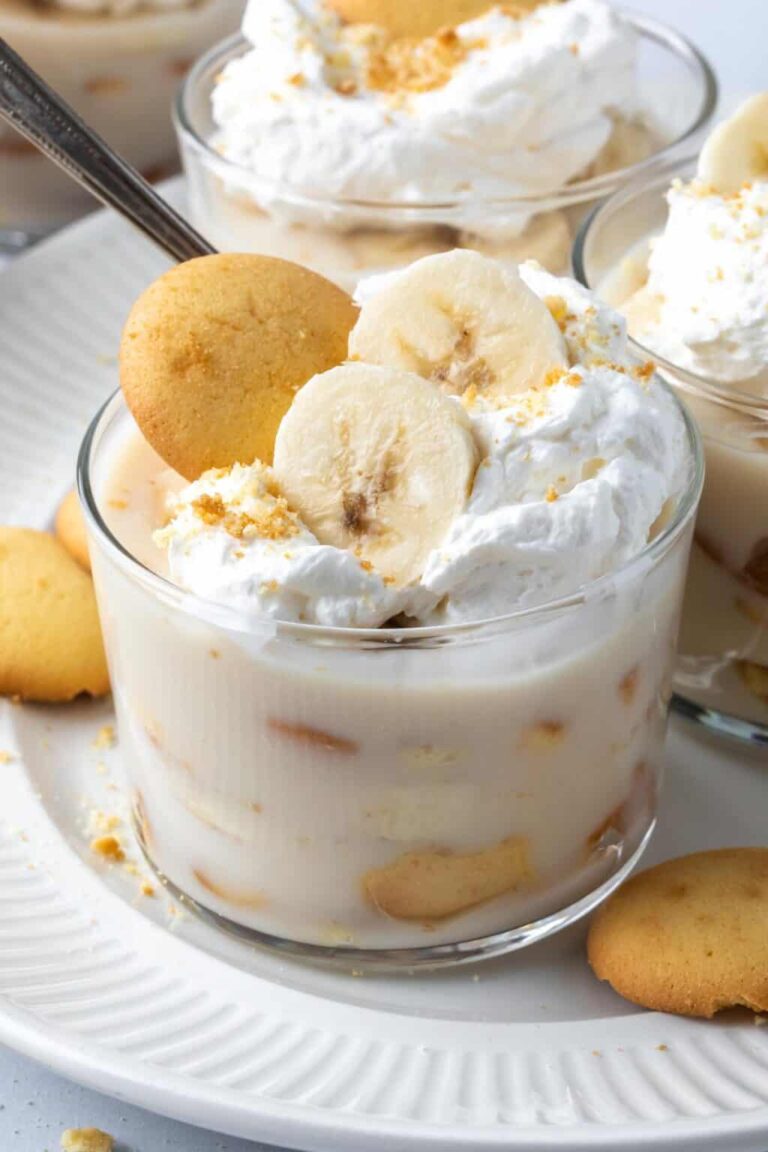 Delicious homemade banana pudding topped with whipped cream and cookies, perfect for baking enthusiasts and dessert lovers. Ideal for showcasing cake and dessert supplies.