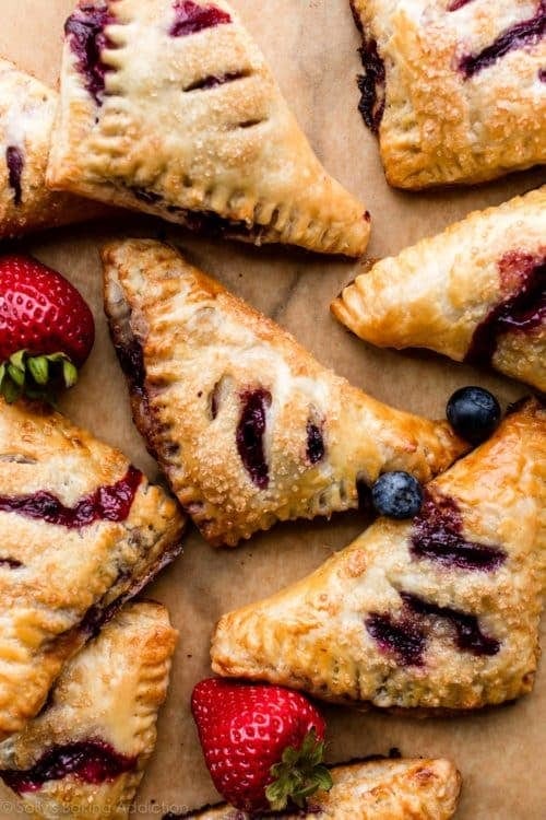 Delicious homemade summer berry turnovers with flaky pastry and fresh berry filling. Perfect for summer desserts or snacks, showcasing vibrant berries and golden crust.