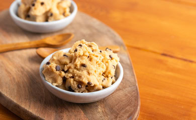 Freshly made cookie dough with chocolate chips in a white bowl, perfect for cake decorating and baking. Showcasing quality ingredients from Over the Top Cake Supplies.