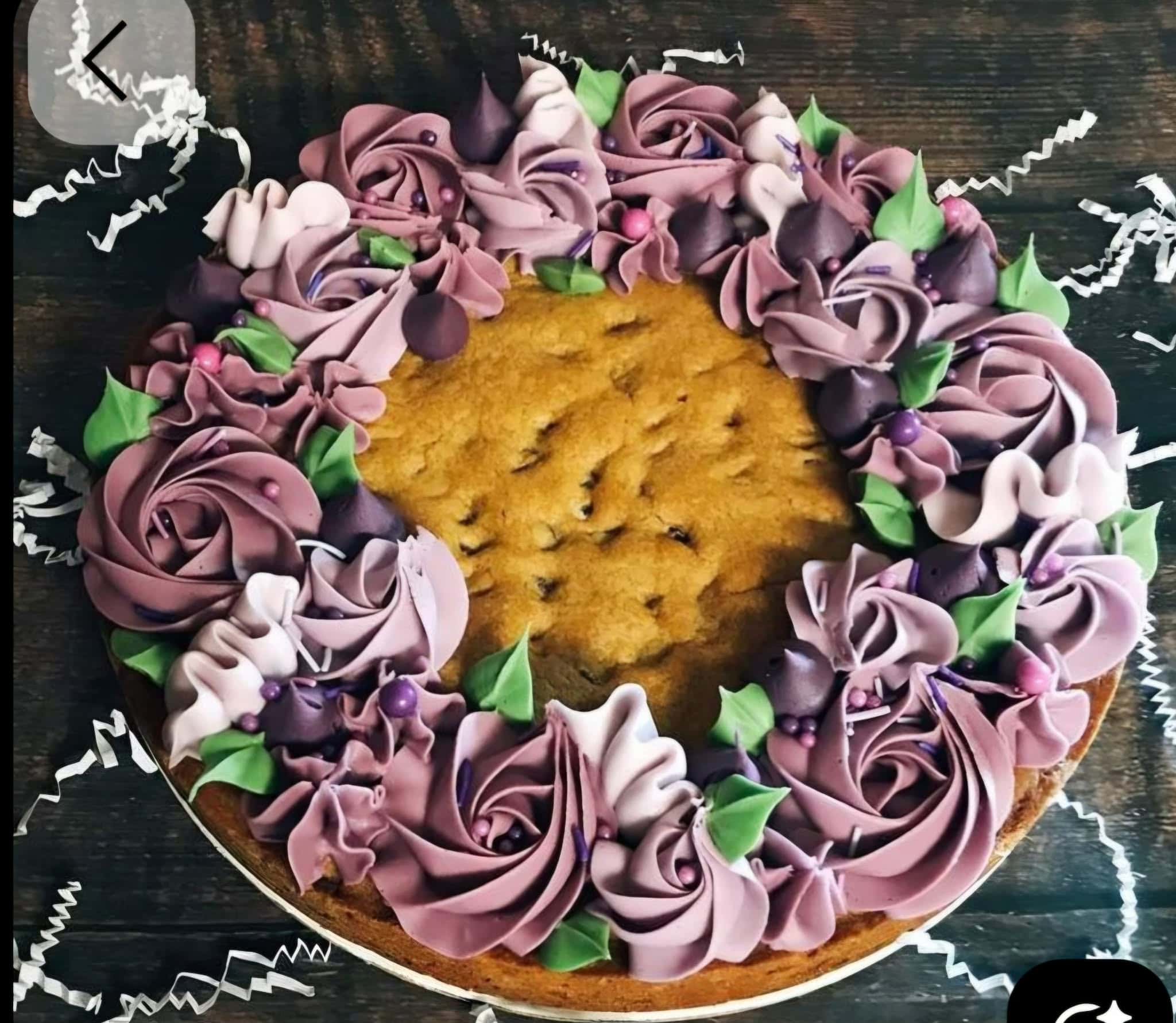 Elegant purple flower cake decorated with buttercream roses and green leaves, perfect for celebrations. Crafted with high-quality cake supplies from Over the Top Cake Supplies.