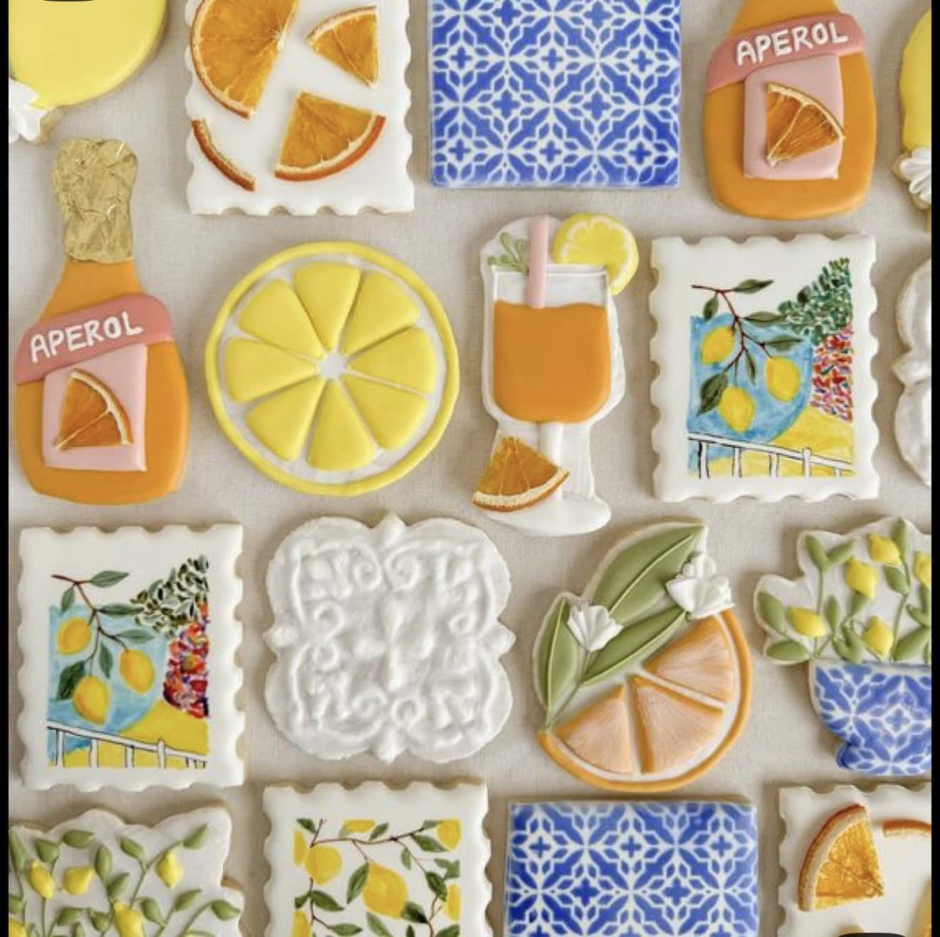 Assorted lemon and citrus-themed decorated cookies and treats, including lemonade bottles, orange slices, and floral designs, perfect for summer parties and celebrations.