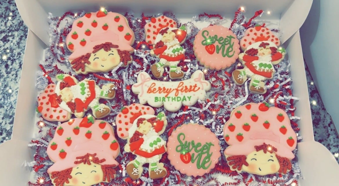 Decorative strawberry-themed cookies for birthday celebrations.