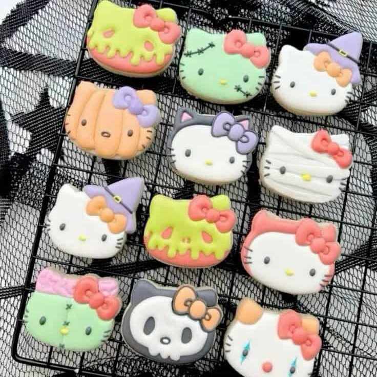 Cute Hello Kitty and Halloween-themed decorated cookies on a cooling rack, perfect for cake decorating and bakery supplies from Over the Top Cake Supplies.