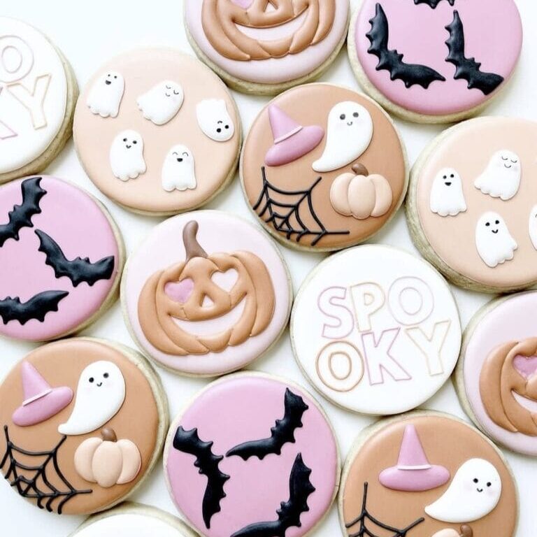 Pumpkin and Halloween themed decorated sugar cookies with ghosts, bats, witches hats, pumpkins, and "spooky" text, perfect for Halloween celebrations and cake decorating supplies.