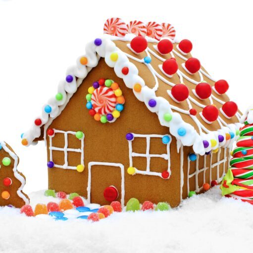 Gingerbread house decorated with colorful candies, icing, and gumdrops, perfect for holiday celebrations. Over the Top Cake Supplies offers premium cake decorating tools and supplies.