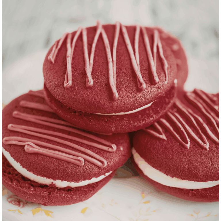 Delicious red velvet cookies with cream filling and pink drizzle, ideal for cake decorating and bakery supplies.